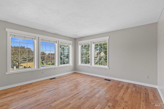 Empty room featuring wood finished floors and a textured ceiling | Image 12