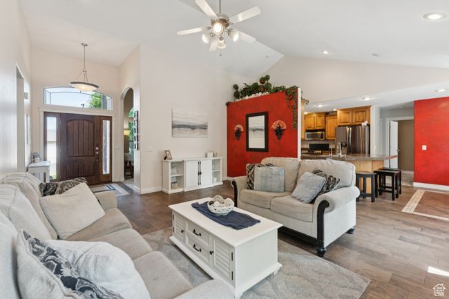 Living area featuring high vaulted ceiling, arched walkways, baseboards, light wood-type flooring, and a ceiling fan | Image 7