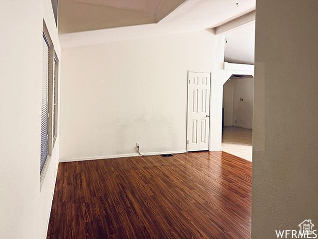 Empty room with baseboards, lofted ceiling, and wood finished floors | Image 4