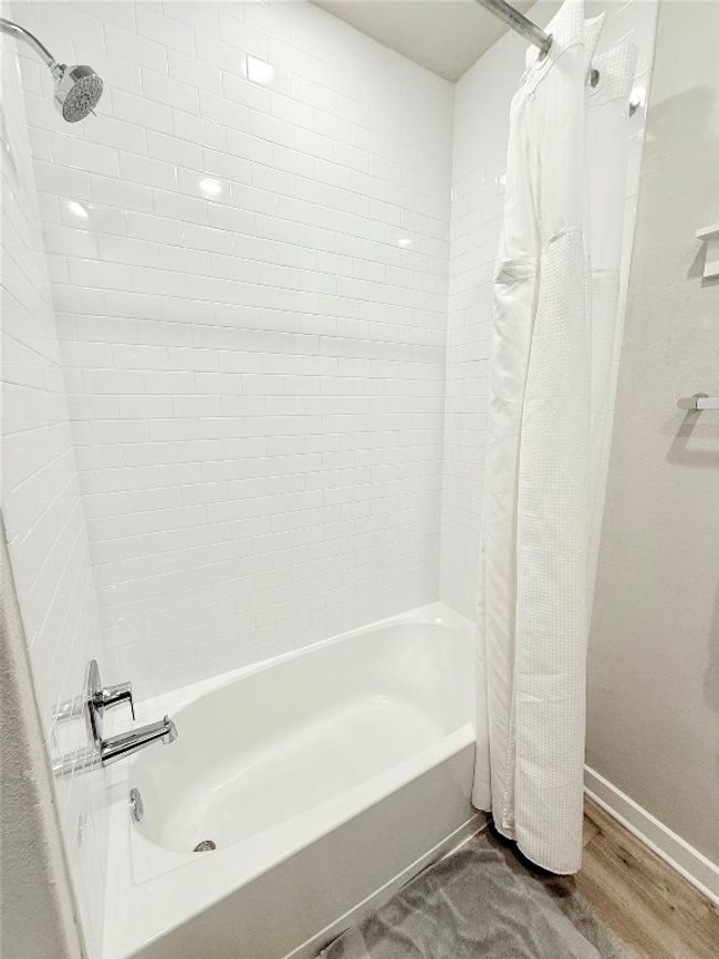 Bathroom with baseboards, shower / bath combo with shower curtain, and wood finished floors | Image 33
