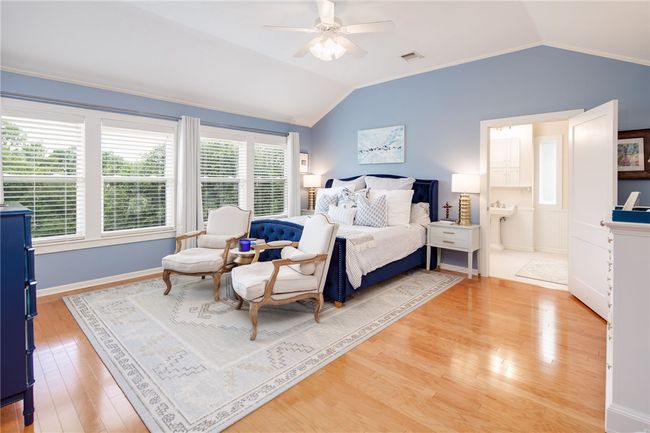Bedroom with vaulted ceiling, light wood-type flooring, connected bathroom, and a ceiling fan | Image 20