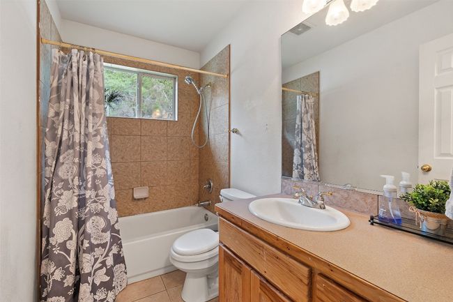 Bathroom with vanity, toilet, shower / bath combo, and tile patterned floors | Image 31