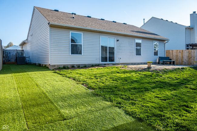 rear view of property with a patio area, central air condition unit, a yard, and fence | Image 6