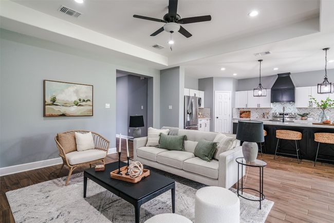 Living area featuring baseboards, light wood finished floors, recessed lighting, a ceiling fan, and a raised ceiling | Image 4