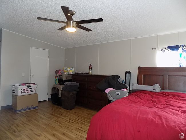 Bedroom with lofted ceiling, hardwood / wood-style floors, a textured ceiling, and ceiling fan | Image 18
