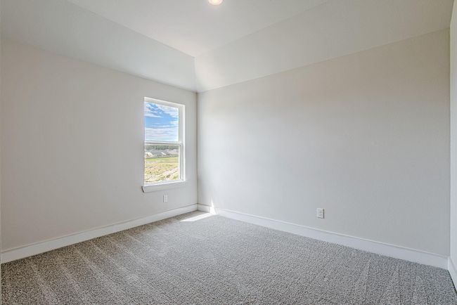 Bright and airy secondary bedroom with soft neutral tones, plush carpet, and large windows offering peaceful neighborhood views and abundant natural light. | Image 39