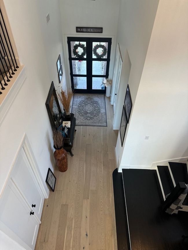 Foyer featuring french doors, light wood finished floors, a towering ceiling, and visible vents | Image 5