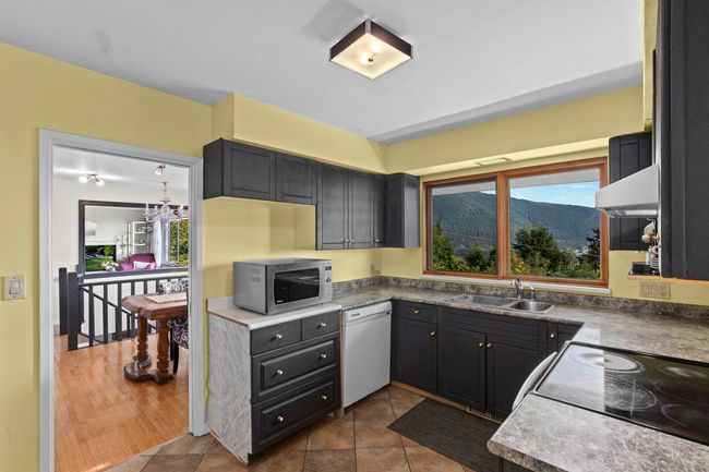 Kitchen with a sink, dishwasher, electric range oven, stainless steel microwave, and under cabinet range hood | Image 8