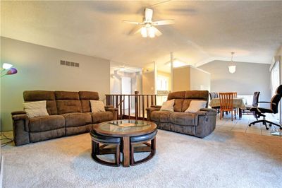 Living room with ceiling fan, light carpet, and lofted ceiling | Image 3