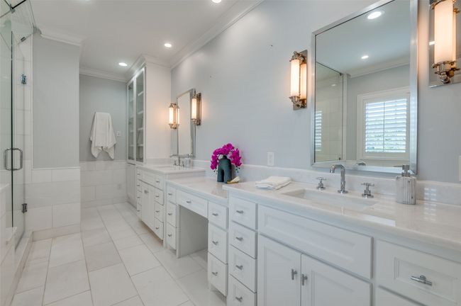 Full bath with crown molding, a shower stall, double vanity, tile patterned floors, and a sink | Image 16