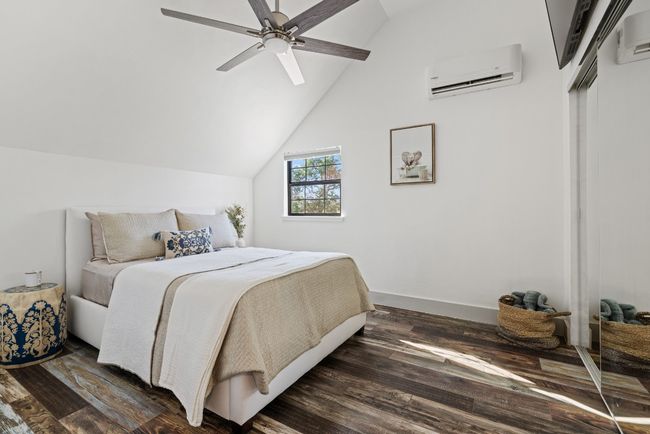 Upstairs Bedroom with a wall unit AC, wood finished floors, vaulted ceiling, and ceiling fan | Image 36