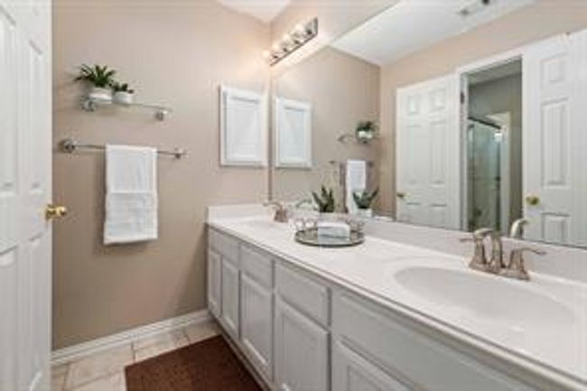 Full bath featuring tile patterned flooring, double vanity, baseboards, and a sink | Image 31