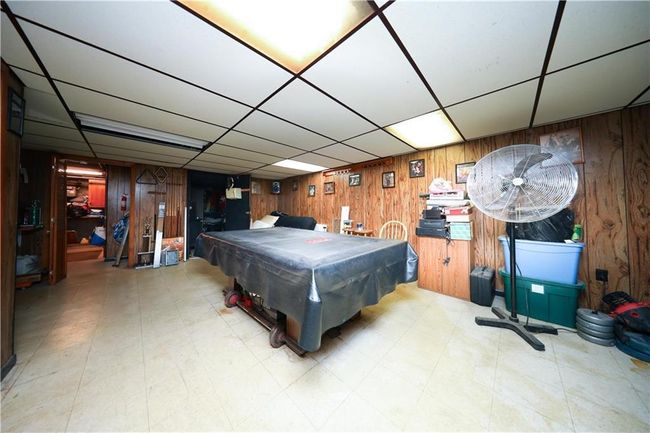 Recreation room featuring wooden walls, pool table, tile patterned floors, and a drop ceiling | Image 21