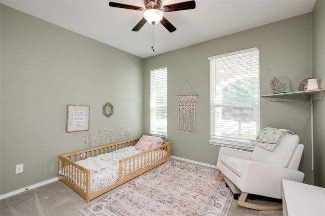 Carpeted bedroom with a crib, multiple windows, and ceiling fan | Image 20