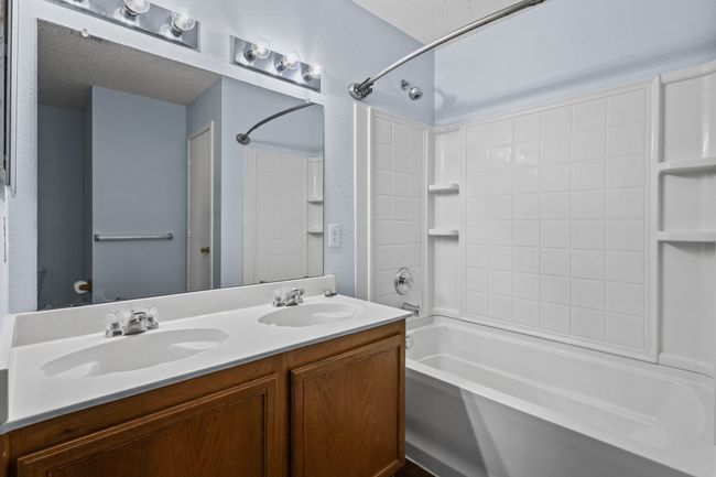 Bathroom with a textured ceiling, shower / bathtub combination, and vanity | Image 12