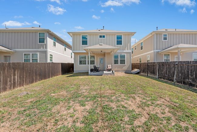 Back of property with a patio, a lawn, board and batten siding, and a fenced backyard | Image 19