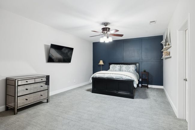 Guest suite with statement navy accent wall and storage. | Image 37