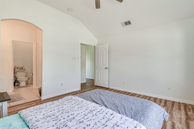 Bedroom with tile floors, ceiling fan, vaulted ceiling, and ensuite bath | Image 20