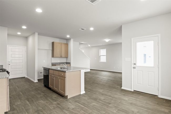 Kitchen featuring a sink, baseboards, dark wood finished floors, light stone counters, and dishwasher | Image 12
