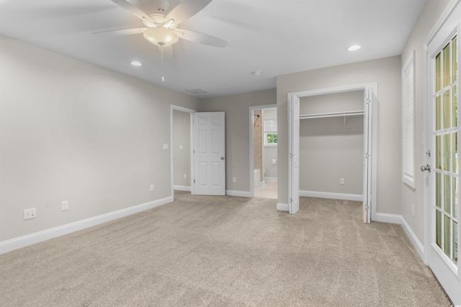 Unfurnished bedroom featuring light colored carpet, baseboards, recessed lighting, ensuite bathroom, and a ceiling fan | Image 25