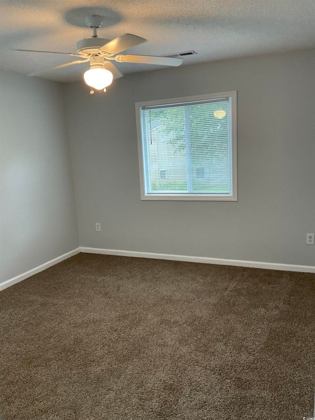 Empty room featuring dark carpet and ceiling fan | Image 8