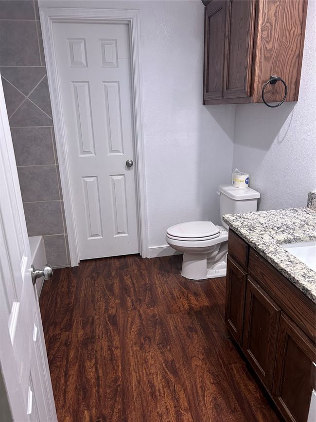 Bathroom featuring wood finished floors, vanity, and a tub to relax in | Image 19