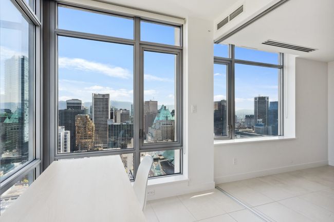 Interior space with a wealth of natural light, visible vents, a city view, and baseboards | Image 11