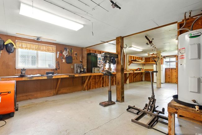 Misc room with a workshop area, water heater, and concrete floors | Image 32