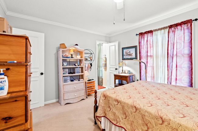Bedroom with light colored carpet and ornamental molding | Image 19