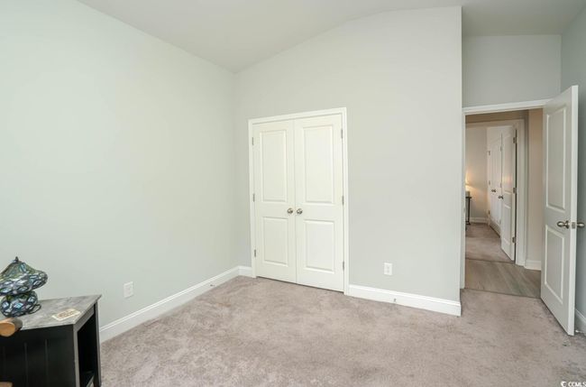 Unfurnished bedroom with lofted ceiling, light carpet, baseboards, and a closet | Image 15