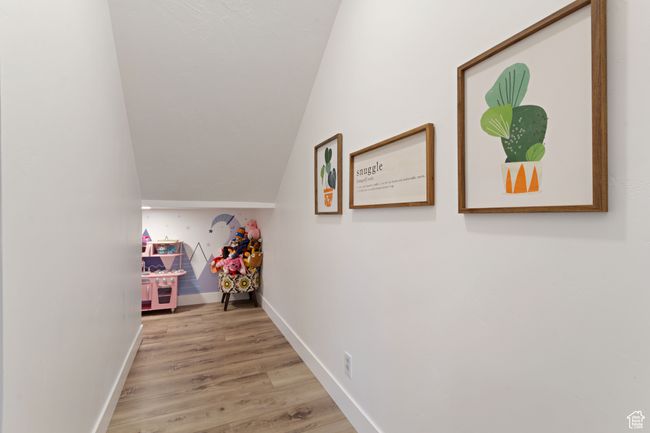 Hall with lofted ceiling, baseboards, and wood finished floors | Image 30