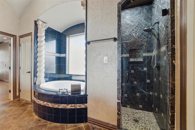 Bathroom featuring a garden tub, tiled shower, tile patterned floors, and a textured wall | Image 16