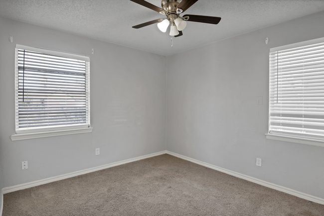 Carpeted spare room featuring baseboards, a textured ceiling, and ceiling fan | Image 16