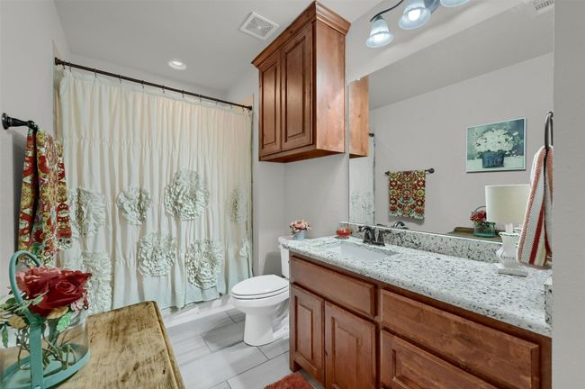 Full bathroom with visible vents, curtained shower, toilet, and vanity | Image 23