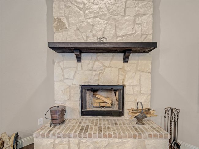 Detailed view of baseboards and a stone fireplace | Image 16