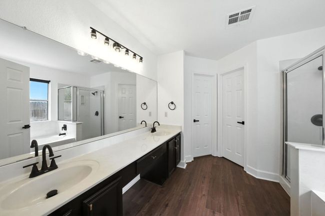 Full bath with a stall shower, wood finished floors, a bath, and double vanity | Image 17
