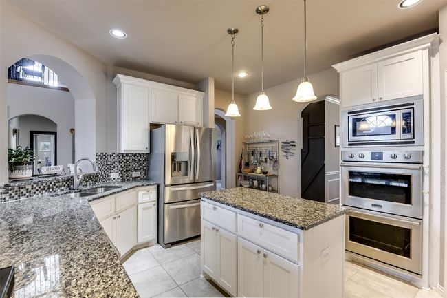 Kitchen with white cabinets, stainless steel appliances, and sink | Image 17