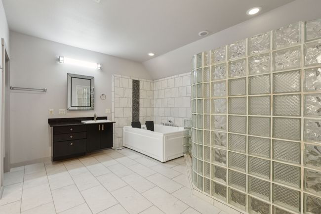 Bathroom featuring vanity, vaulted ceiling, tile patterned floors, and separate shower and tub | Image 26