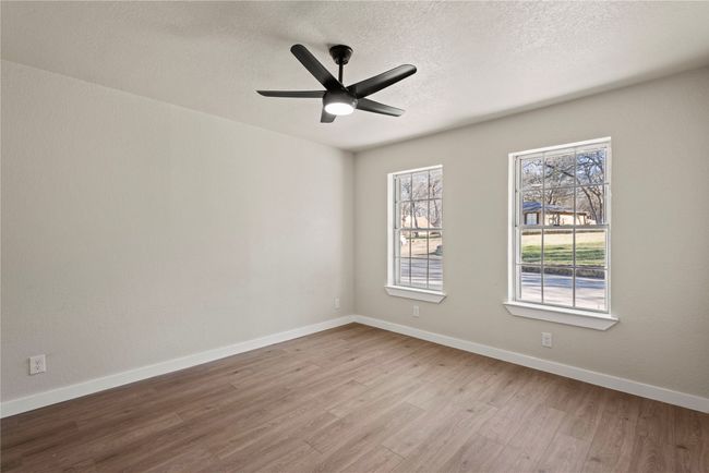 Spare room with light wood-style flooring, baseboards, ceiling fan, and a textured ceiling | Image 15