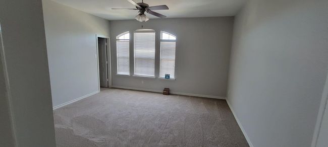 Carpeted spare room with baseboards and a ceiling fan | Image 11