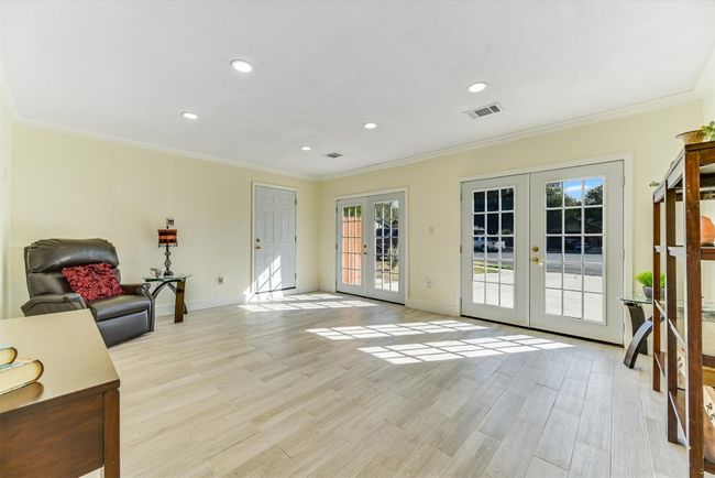 With double doors that open to the driveway, this converted garage offers a flexible bonus space, perfect for a game room, home gym, studio, or whatever you dream up | Image 10