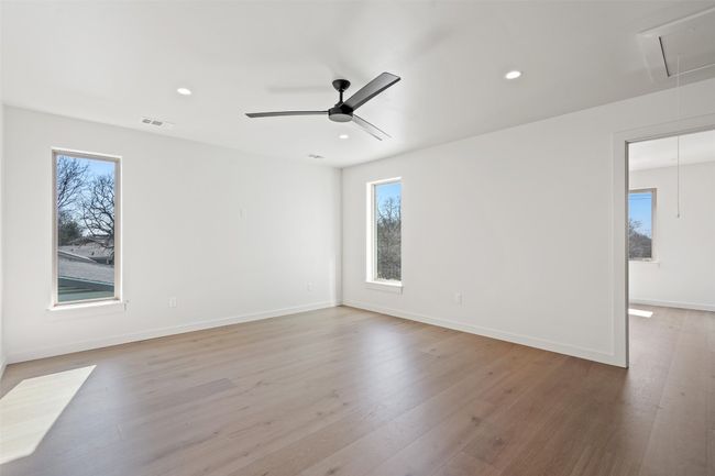 Empty room featuring plenty of natural light, attic access, visible vents, and light wood finished floors | Image 13