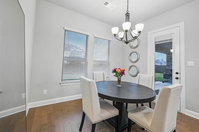 Dining space featuring a chandelier and dark wood-style flooring | Image 19