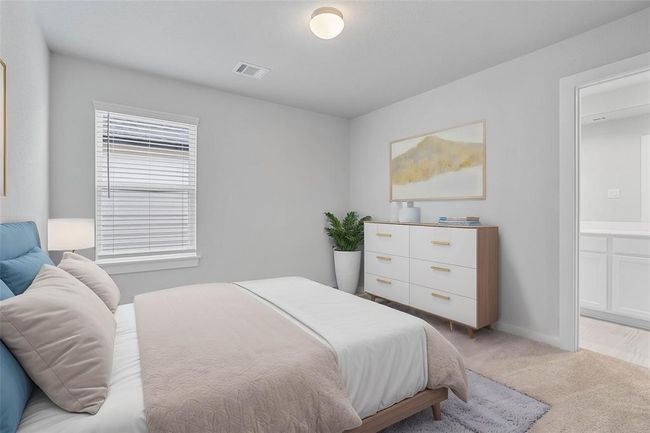 Secondary bedroom features plush carpet, neutral paint, large window with privacy blinds, and its own private access to a secondary bathroom. | Image 18