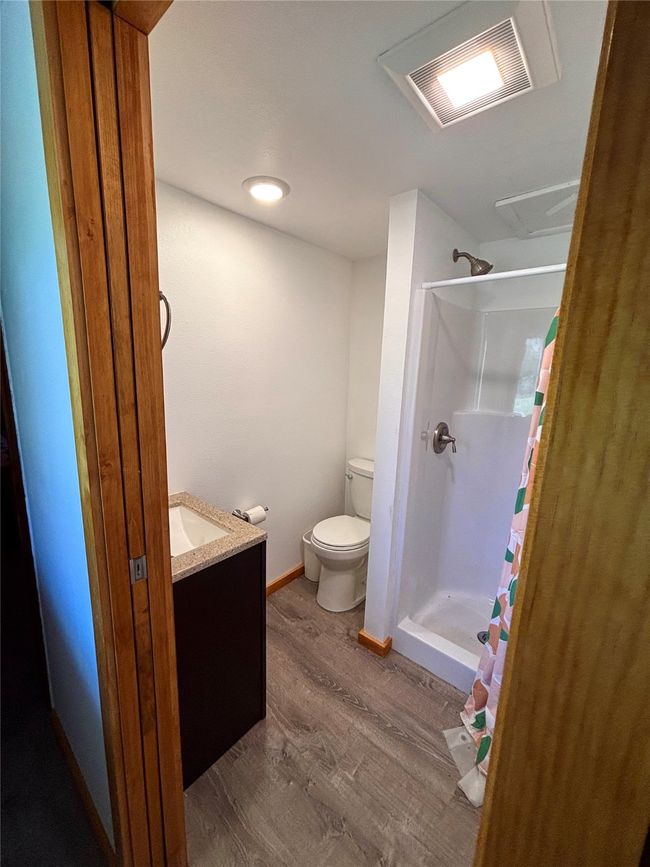 Bathroom featuring a shower with shower curtain, wood finished floors, and vanity | Image 20
