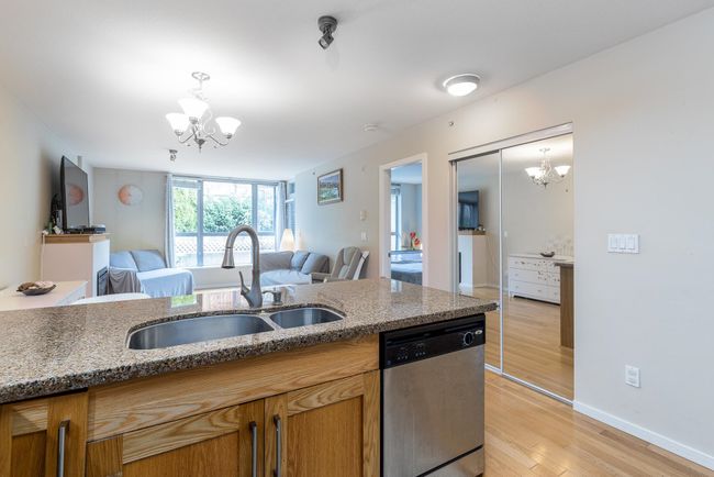 Kitchen with dishwasher, light wood-style floors, a chandelier, and a sink | Image 7