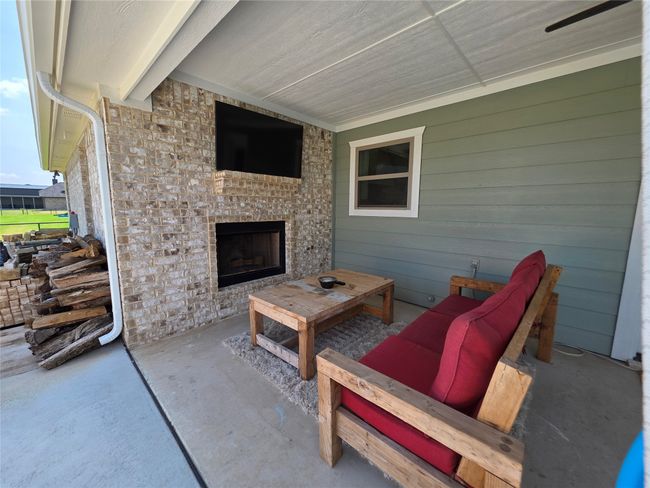 View of patio featuring an outdoor brick fireplace | Image 34