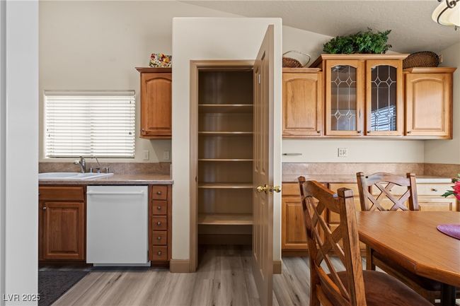Kitchen with dishwasher, glass insert cabinets, and light wood finished floors | Image 12