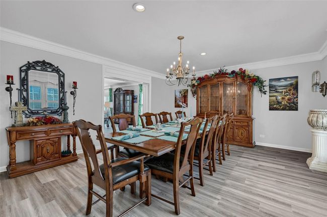 Dining area featuring crown molding, a chandelier, baseboards, light wood-style floors, and recessed lighting | Image 19