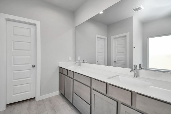 Escape to a spa-like oasis in this primary bathroom. Enjoy a walk-in shower with tile surround, a separate garden tub with custom detailing, and an elegant vanity featuring light countertops, modern hardware, and beautiful recessed lights. Experience luxury and relaxation in every detail. | Image 26